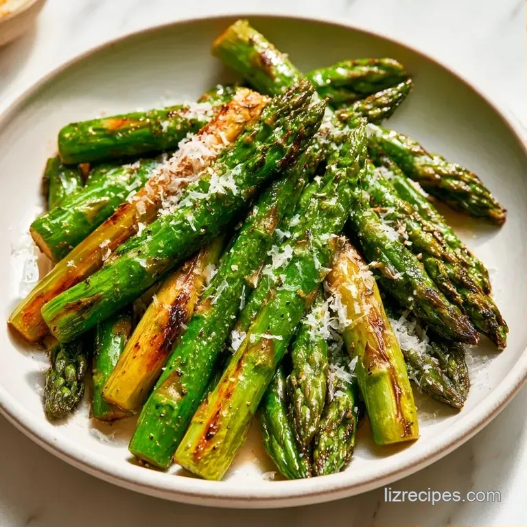 Neat rows of charred green asparagus on a dark slate platter, dusted with snowy parmesan and a bright lemon wedge.