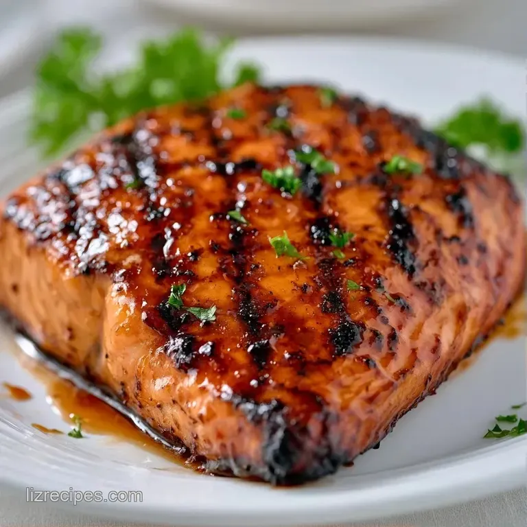 A seared salmon fillet resting on vibrant saut&eacute;ed spinach with a lemon wedge and fresh sprigs of green parsley.