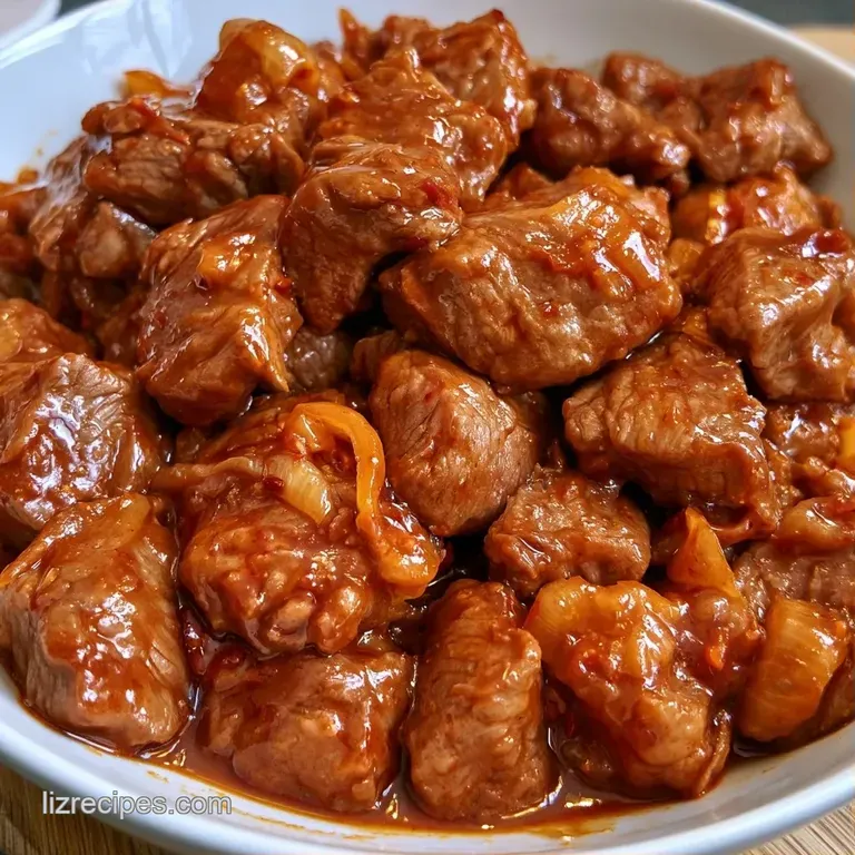 Tender shredded beef in a rich brown sauce atop a bed of steamed rice, garnished with bright sliced green onions.